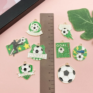 Vue détaillée de breloques de football émaillées avec règle pour échelle de taille