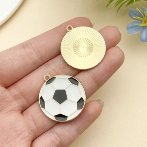 Détail du pendentif de football avec émail noir et blanc et texture en métal doré