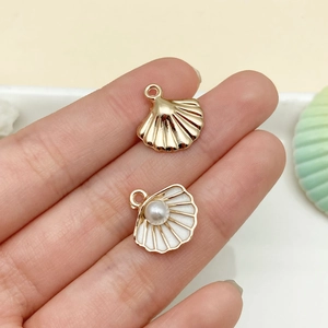Detailed view of alloy shell pendants with faux pearls and white enamel for DIY jewelry