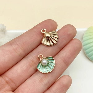 Detailed view of alloy shell pendants with green enamel and pearl inlay for jewelry DIY