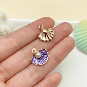 Detail of gold shell pendant with purple enamel and pearl on a sea-themed background