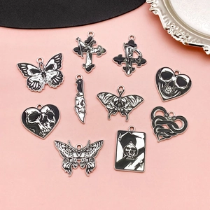 Detailed view of Gothic black and white enamel charms including skulls and butterflies