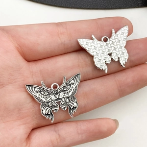 Macro shot of silver-tone and black enamel butterfly charms for DIY jewelry making