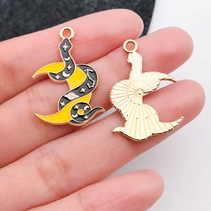 Détail de pendentifs émaillés lune et serpent montrant les motifs et la texture au dos