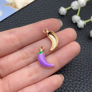 Detail of purple enamel chili pendants showing the smooth front and textured back finish