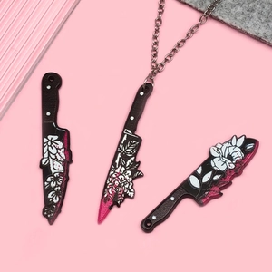 Three acrylic cleaver pendants with floral pattern on pink background for Halloween