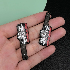 Detail of acrylic chef knife charms with gothic floral patterns and red blood splatters