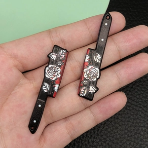 Detail of acrylic cleaver charms featuring white roses and red blood splatters