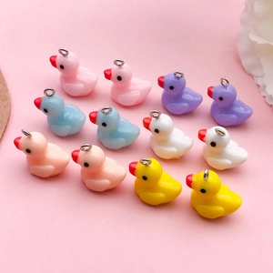 Flat lay of colorful resin mini duck charms for DIY jewelry making and crafts