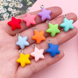 Colorful resin star charms with metal rings for DIY jewelry making held in hand