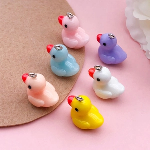 Close-up of colorful resin duck charms with silver metal rings for DIY jewelry