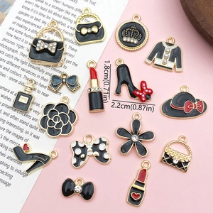 Flat lay of alloy DIY jewelry charms including lipstick and high heel shapes with pearls