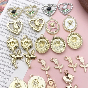 Detailed view of various vintage style rose and flower alloy charms for DIY jewelry making