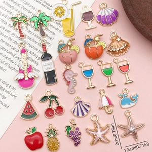 Flat lay of colorful summer enamel charms featuring fruits and drinks for DIY jewelry