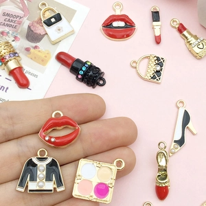 Detalle de colgantes de esmalte con temática de moda como pintalabios y tacones