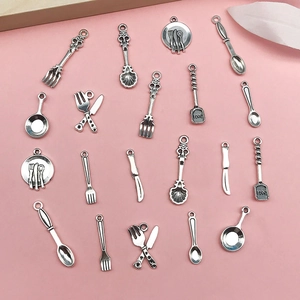 Makroaufnahme silberner Küchenutensilien-Anhänger mit Love-Gravur für DIY-Schmuck
