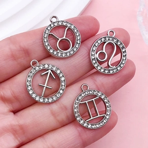 Dettaglio di ciondoli zodiacali placcati argento con bordi di strass brillanti