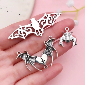 Detailed view of three antique silver bat charms for DIY gothic jewelry making