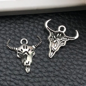 Detailed front and back view of vintage silver bull skull alloy pendants for DIY jewelry