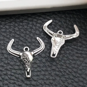 Macro detail of antique silver bull head pendants with vintage engraved patterns