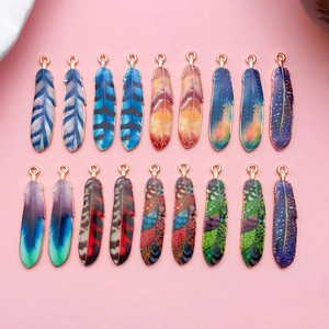 Vue détaillée de 18 pendentifs plumes colorés en alliage avec émail goutte à goutte