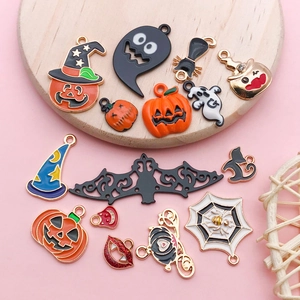 Vista macro de dijes de esmalte de Halloween con calabazas y fantasmas en bandeja madera