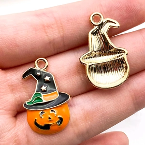 Détail de breloque citrouille d'Halloween montrant l'émail avant et le dos en métal doré