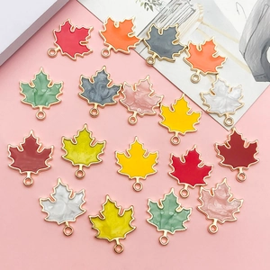 Macro shot of maple leaf alloy pendants with colorful enamel details for DIY jewelry making