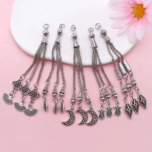 Detailed view of antique silver moon and floral tassel pendants for DIY jewelry design