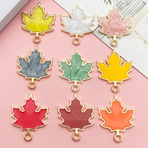 Macro view of assorted maple leaf alloy charms in nine colors for DIY jewelry making