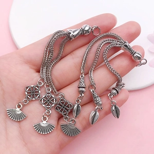 Vintage silver alloy tassel pendant with moon flower details and woven chain elements