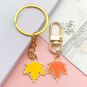 Macro shot of maple leaf charms in yellow and orange with gold lobster clasps and keyrings