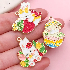 Vue détaillée de trois breloques lapin en émail avec fraises et fleurs pour bijoux DIY