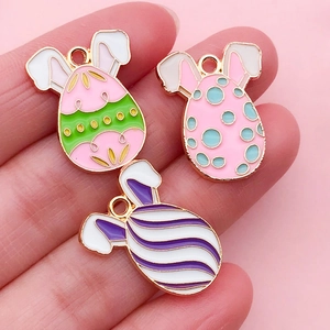 Macro view of colorful Easter bunny egg enamel pendants with gold alloy plating