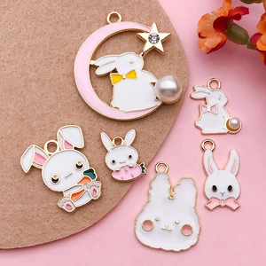 Detailed view of various colorful enamel rabbit charms with pearls and carrots for DIY crafts