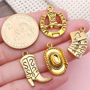 Pendentifs cowboy dorés sur la paume avec pièce de 1 dollar pour échelle de taille