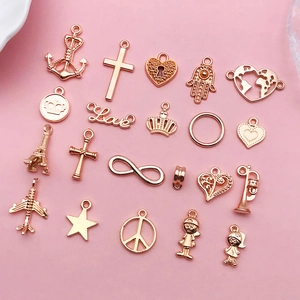 Close-up of assorted rose gold alloy charms including cross and crown for DIY jewelry making
