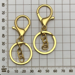 Golden lobster clasp keychain with chain length measurement of 70mm on a grid scale