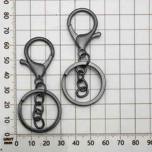 Detail view of two gunmetal alloy lobster clasps with keychains measuring 75mm length