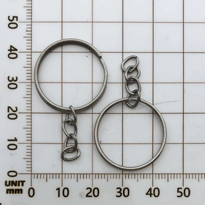 Close-up of a 28mm metal key ring with a short 3-link chain on a millimeter measurement grid