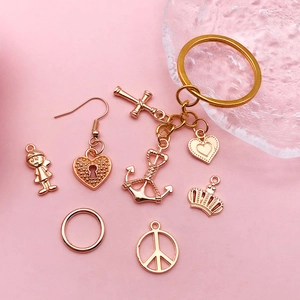 Rose gold vintage alloy charms set featuring anchor cross and heart pendants on pink surface