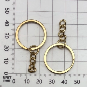 Detailed view of 25mm gold-plated keychain rings with chain on a metric scale grid