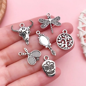 Vue détaillée des breloques en alliage d'argent vintage avec motifs crâne, libellule et bœuf