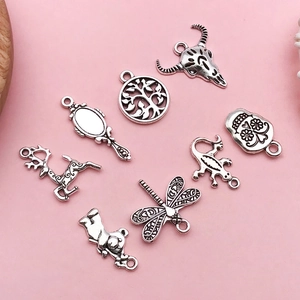 Vue à plat de breloques rétro en alliage aux motifs d'animaux sur fond rose