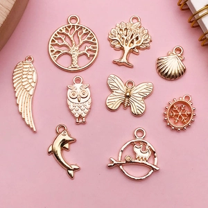 Macro shot of rose gold alloy charms featuring tree of life, butterfly and owl for DIY jewelry
