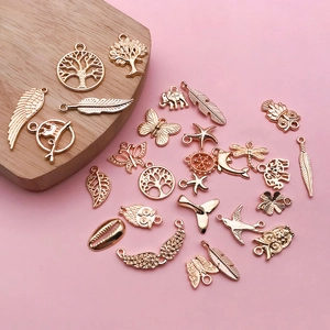 Macro shot of rose gold alloy charms including life tree and feather for DIY jewelry