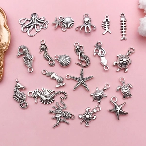 Flat lay of antique silver ocean charms including octopus, starfish, and seahorse for DIY