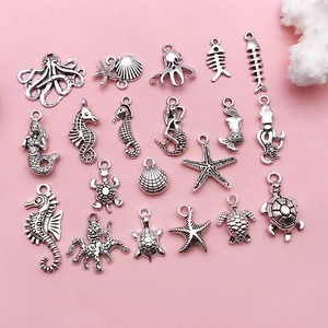 Detailed view of assorted antique silver ocean charms including seahorse and starfish