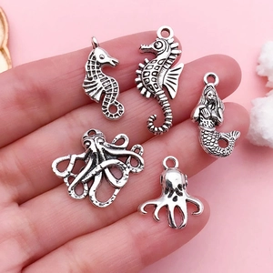 Antique silver sea animal charms including seahorse, mermaid, and octopus pendants