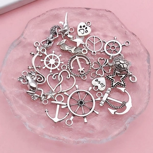 Macro detail of mixed antique silver marine charms including anchor and mermaid shapes